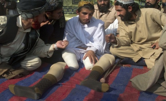 Tribesmen sit with Sadaullah Khan, who lost both legs and one eye in a 2009 drone strike on his house (Reuters)