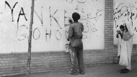 A resident washes "Yankee Go Home" graffiti off a wall in Tehran on August 21, 1953.