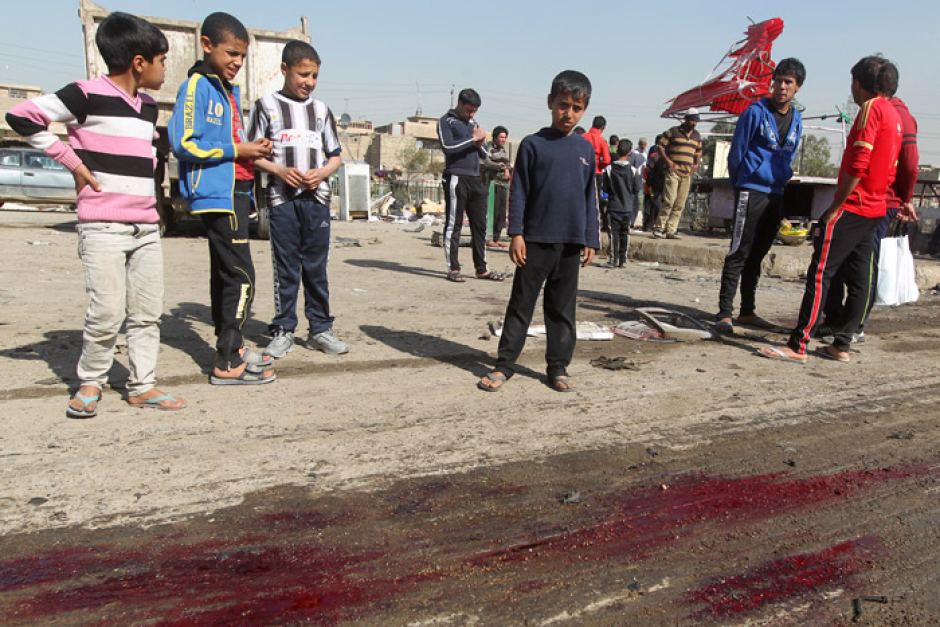 Iraqi Children look at aftermath of a spring bombing in Sadr City, Baghdad (AFP)